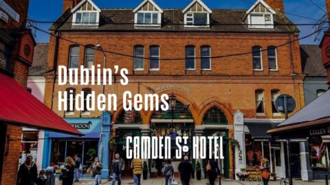 Charming Dublin street, Camden St. Hotel entrance, vibrant shops, relaxed guests strolling, inviting urban experience.