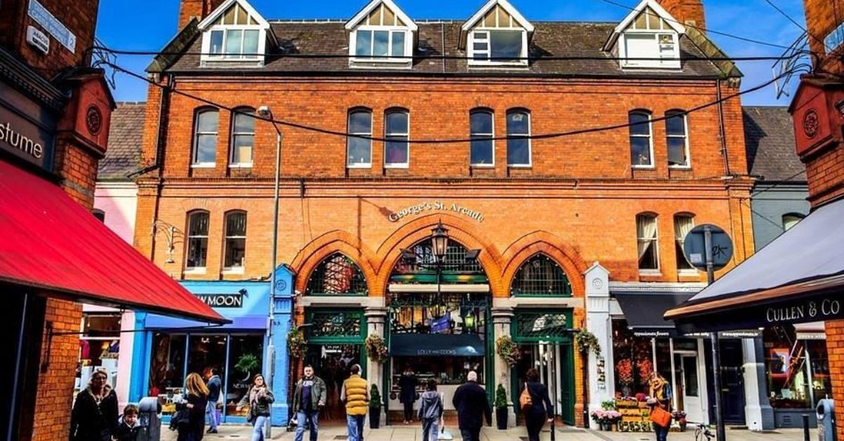 Vibrant pedestrian shopping street with charming brick buildings and boutique shops in a lively hotel district.