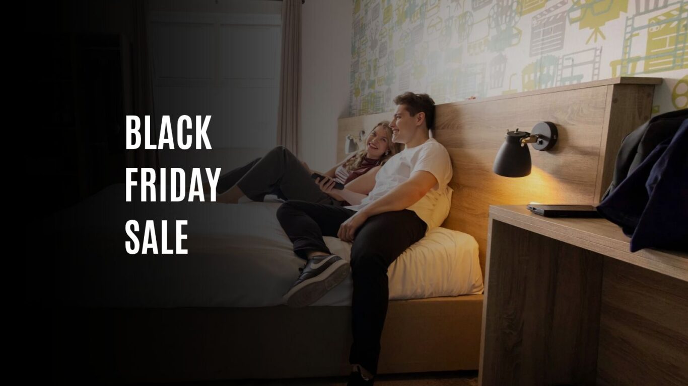 Cosy hotel room with modern decor, a couple relaxing on a comfortable bed, stylish wall art, and soft lighting.